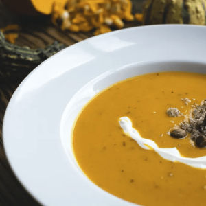 Pumpkin soup with topping on white plate